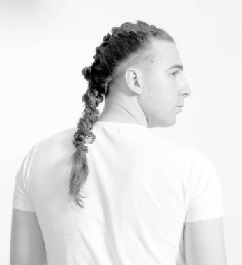 İzole edilmiş arka planda saç örgüleri olan şık bir erkek model. Tarz, saç stili, moda konsepti.