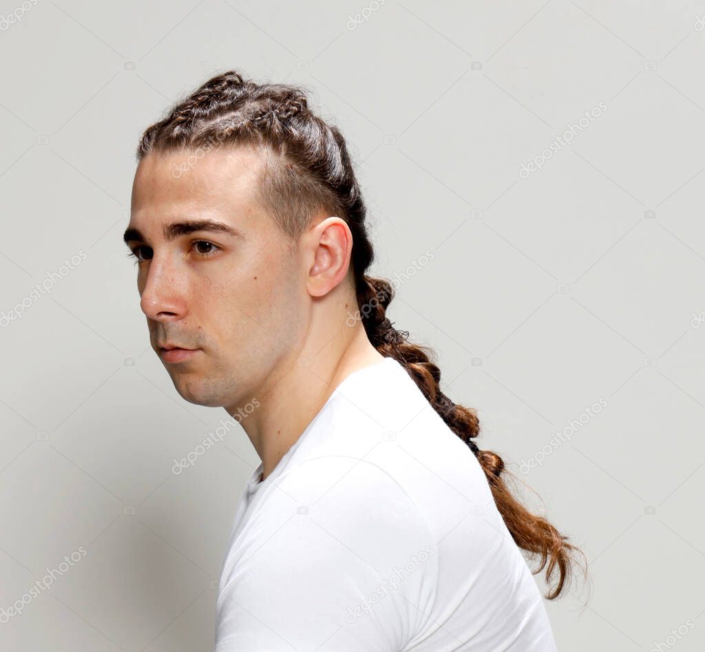 Stylish male model with braids posing in studio on isolated background. Style, hairstyle, fashion concept.