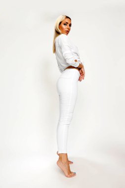 Güzel sarışın kız izole edilmiş arka planda stüdyoda poz veriyor. Tarz, trendler, moda konsepti.