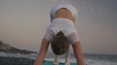 Yoga kavramıyla sağlıklı. Çekici genç kadın gün batımında sahilde Kobra Pozu pratiği yapıyor. Yukarı bakan köpek pozu. Urdhva Mukha Svanasana. Rahat ve rahat..