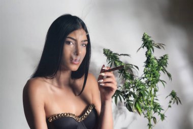 Esrar ve eğlence amaçlı ilaçlar. CBD esrar içen genç bir kadın. 