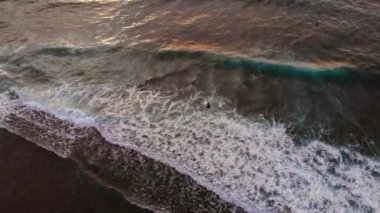 Sunset on tropical beach. Aerial view of ocean waves crushing. Yellow sky with waves coming from Atlantic ocean. Sunset over ocean