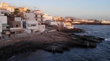 Tenerife, Canary Islands, Spain. September 2022: Aerial view on picturesque La Caleta village on sunset. Spanish destinations and resorts. La Caleta volcanic beach. 