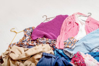 Bir çok farklı giysi beyaz bir zeminde yatıyor..