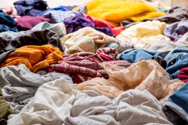 Hafif arka planda kullanılmış giysi yığını. Geri dönüşüm için ikinci el