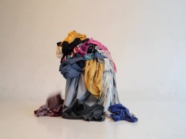 Hafif arka planda kullanılmış giysi yığını. Geri dönüşüm için ikinci el