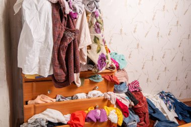 Dolapta ve evin içinde bir sürü kıyafet var. Dağınık konut