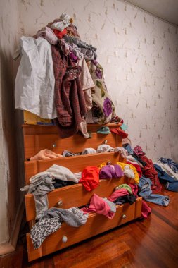 Dolapta ve evin içinde bir sürü kıyafet var. Dağınık konut