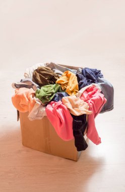 Büyük bir karton kutuda elbise yığını. Gardırop sıralanıyor ve düşülüyor