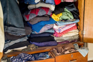 Dolapta kıyafet ve tekstil tıkanmış. İkinci el tekrar kullanım. Dolabın temizlenmesi ve temizlenmesi