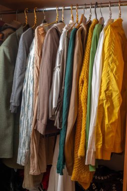 Dolaptaki askılarda bir sürü parlak renkli kıyafet var. Dolabı boşaltıyorum. İkinci el.
