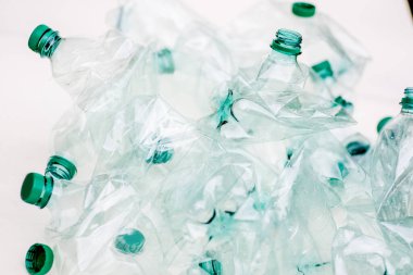 Beyaz arka planda bir yığın buruşmuş plastik şişe.