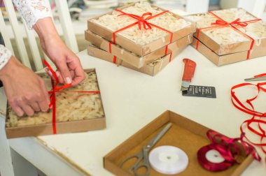 Hediye paketi. Kadın elleri kutuyu paketler.