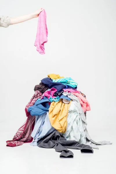 手把衣服和旧衣服扔在一起 用过的衣服堆在轻薄的背景上 二手回收 — 图库照片