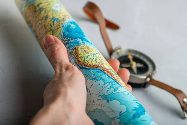 Verdrehte Landkarte Der Hand Vor Dem Hintergrund Des Kompasses — Stockfoto
