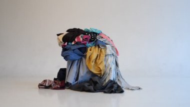 Hafif arka planda kullanılmış giysi yığını. Geri dönüşüm için ikinci el