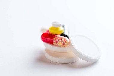 Beyaz arka planda çok renkli haplar ve kapsüller.