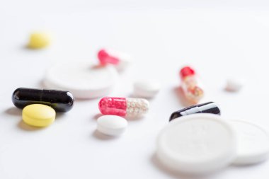 Beyaz arkaplandaki çok renkli tabletler ve kapsüller