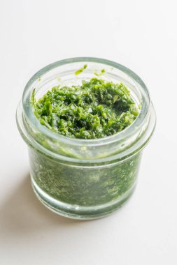 Beyaz arka planda kavanozda pesto sosu