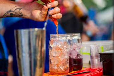 Barmen dışarıda plastik bardakta kokteyl hazırlıyor. yemek servisi.