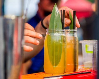 Barmen dışarıda plastik bardakta kokteyl hazırlıyor. yemek servisi.