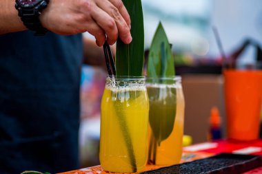 Barmen dışarıda plastik bardakta kokteyl hazırlıyor. yemek servisi.