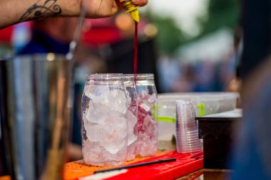 Barmen dışarıda plastik bardakta kokteyl hazırlıyor. yemek servisi.