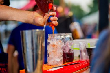 Barmen dışarıda plastik bardakta kokteyl hazırlıyor. yemek servisi.