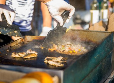 Adam sebzeli pilav pişiriyor.