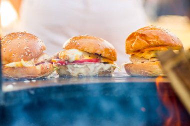 Ticari bir mutfakta üç tane iştah açıcı uzun burger. Hazır düzen