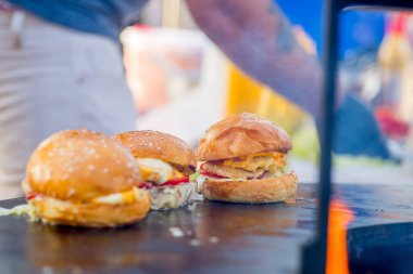 Ticari bir mutfakta üç tane iştah açıcı uzun burger. Hazır düzen