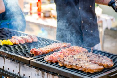 Mangalda balık bifteği. Somon parçaları açık ateşte kızarır. Ateş ve duman balık parçalarının üzerinde yuvarlanıyor.