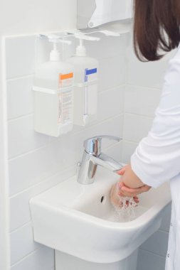 El yıkama ve dezenfektan. Doktor hastaları kabul etmeye hazırlanıyor.