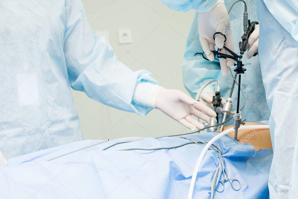 Surgeon performs laparoscopic surgery on the abdomen. Close-up of a laparoscope and doctor's hands