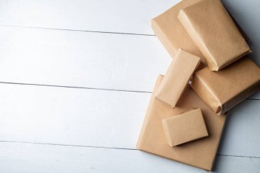 Beyaz arkaplandaki Kraft kağıdına sarılı hediyeler