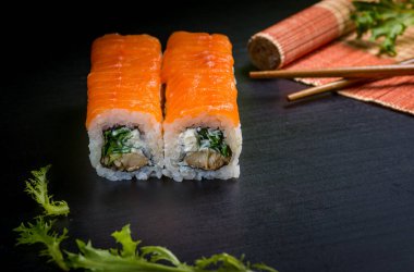 Japon suşisi ve siyah bir arka planda rulo