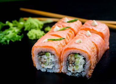Japon suşisi ve siyah bir arka planda rulo