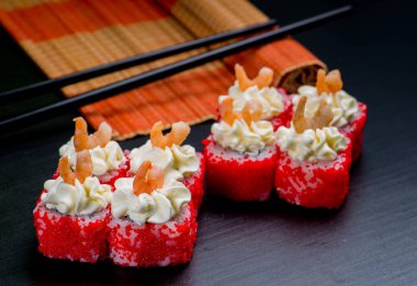 Japon suşisi ve siyah bir arka planda rulo