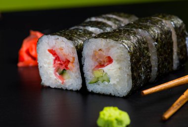 Japon suşisi ve siyah bir arka planda rulo