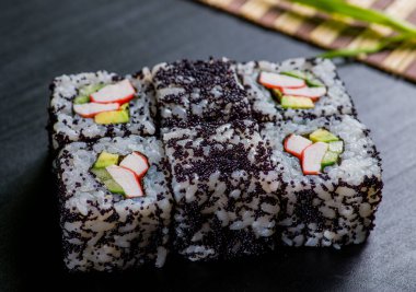 Japon suşisi ve siyah bir arka planda rulo