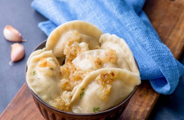 Doldurulmuş hamur tatlısı ve sos tabakta. Bir tabağın üzerinde buhar