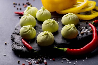 Donmuş khinkali ve koyu arkaplanlı baharatlı hamur tatlısı. Yarı bitmiş ürünler