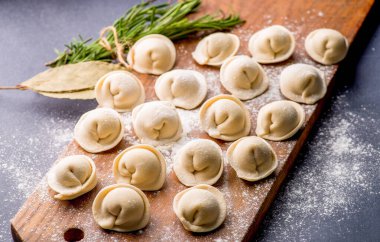 Donmuş khinkali ve koyu arkaplanlı baharatlı hamur tatlısı. Yarı bitmiş ürünler