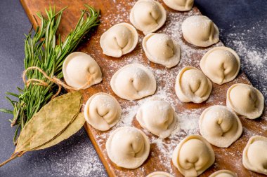 Donmuş khinkali ve koyu arkaplanlı baharatlı hamur tatlısı. Yarı bitmiş ürünler