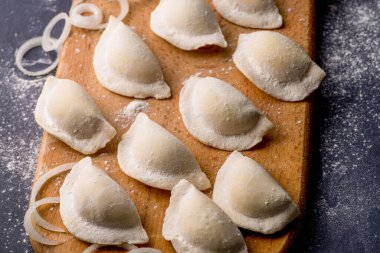 Donmuş khinkali ve koyu arkaplanlı baharatlı hamur tatlısı. Yarı bitmiş ürünler