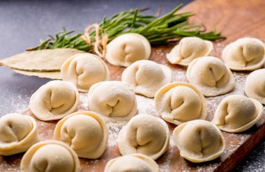 Donmuş khinkali ve koyu arkaplanlı baharatlı hamur tatlısı. Yarı bitmiş ürünler