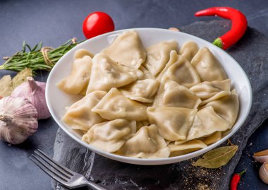Doldurulmuş hamur tatlısı ve sos tabakta. Bir tabağın üzerinde buhar