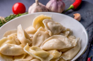 Doldurulmuş hamur tatlısı ve sos tabakta. Bir tabağın üzerinde buhar