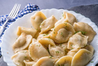 Doldurulmuş hamur tatlısı ve sos tabakta. Bir tabağın üzerinde buhar