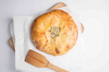 Beyaz arkaplanda servis edilen etli khachapuri turtası.